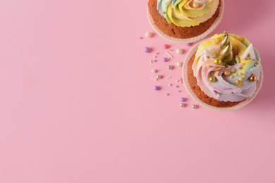 Cute sweet unicorn cupcakes on pink background, flat lay. Space for text