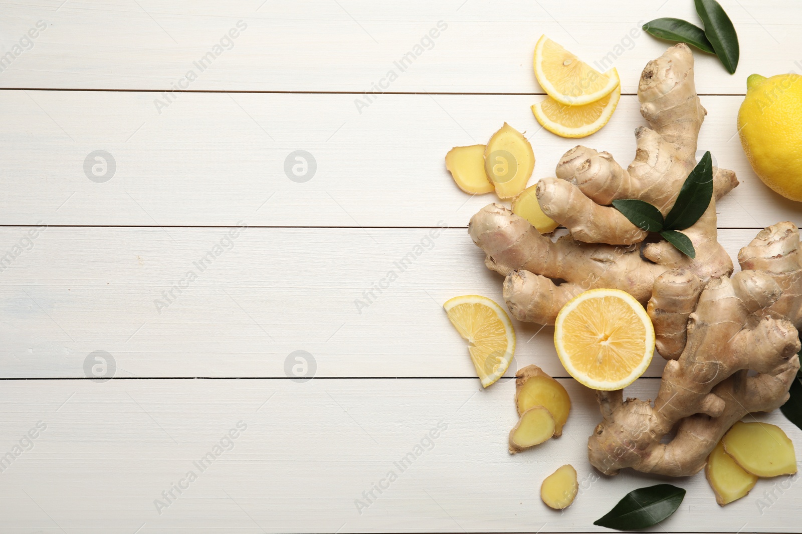 Photo of Fresh lemons and ginger on white wooden table, flat lay. Space for text