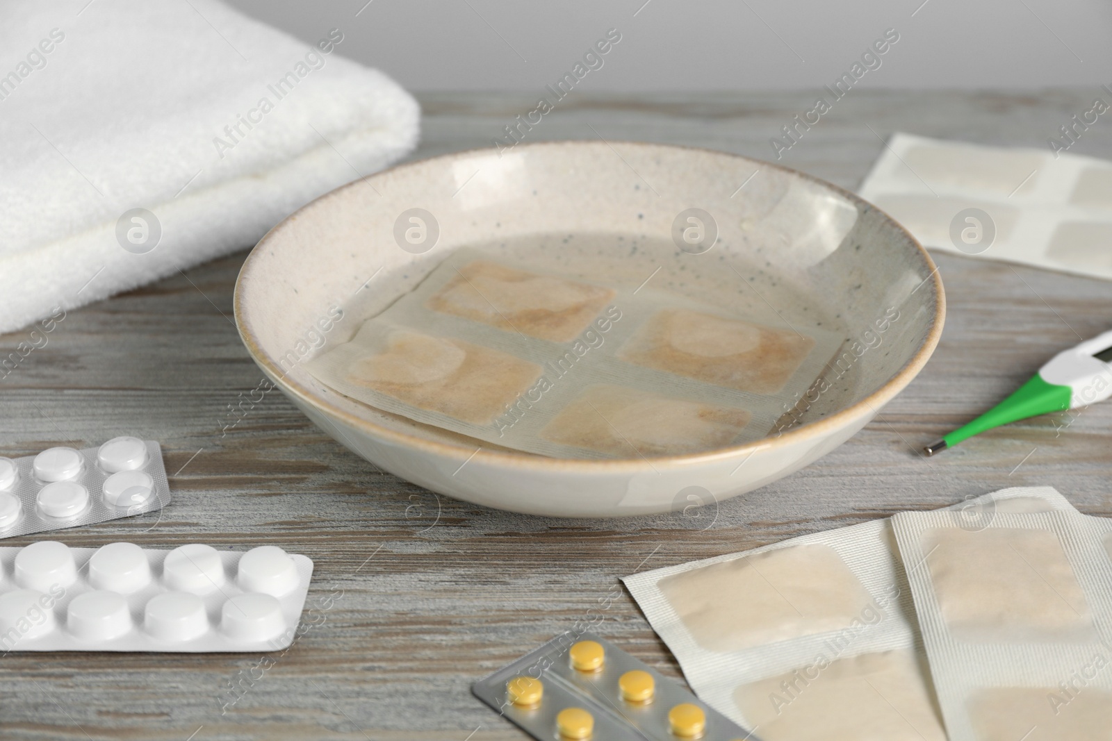 Photo of Mustard plaster in bowl with water on wooden table