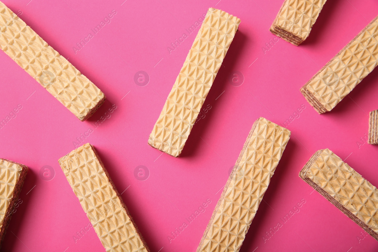 Photo of Flat lay composition with delicious crispy wafers on pink background