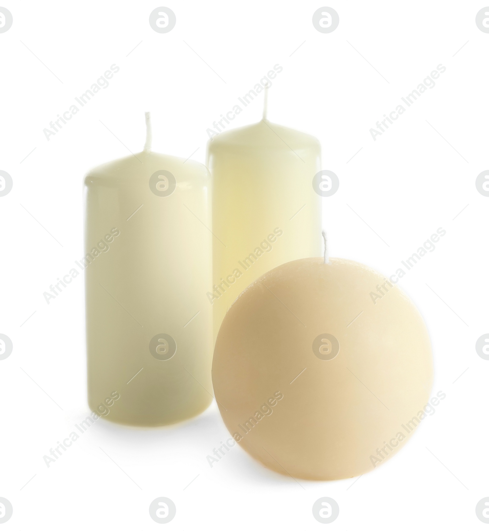 Photo of New wax candles of different shapes on white background