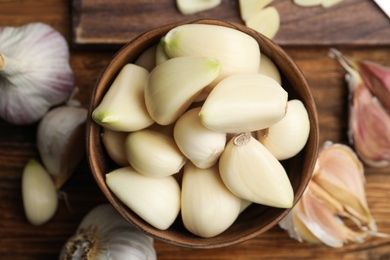 Photo of Fresh organic garlic on wooden table, flat lay