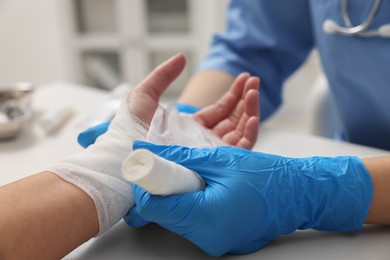 Photo of Doctor bandaging patient's burned hand in hospital, closeup