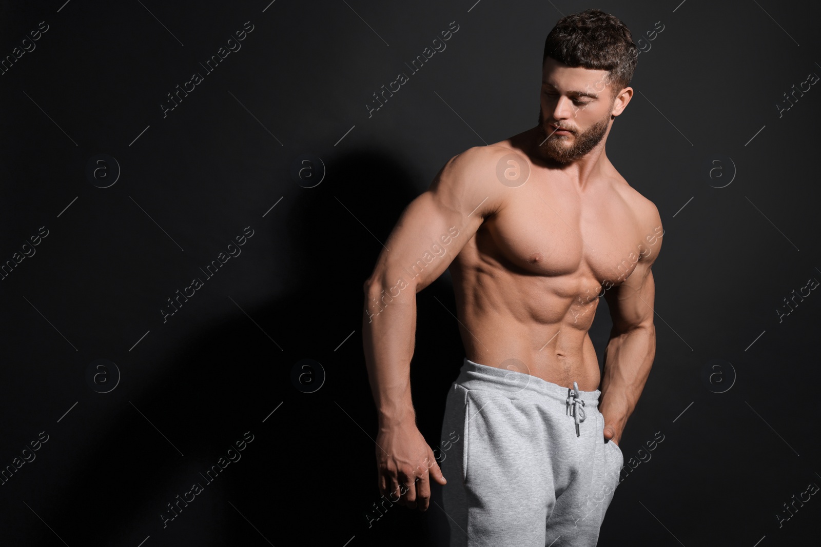 Photo of Handsome muscular man on black background, space for text. Sexy body