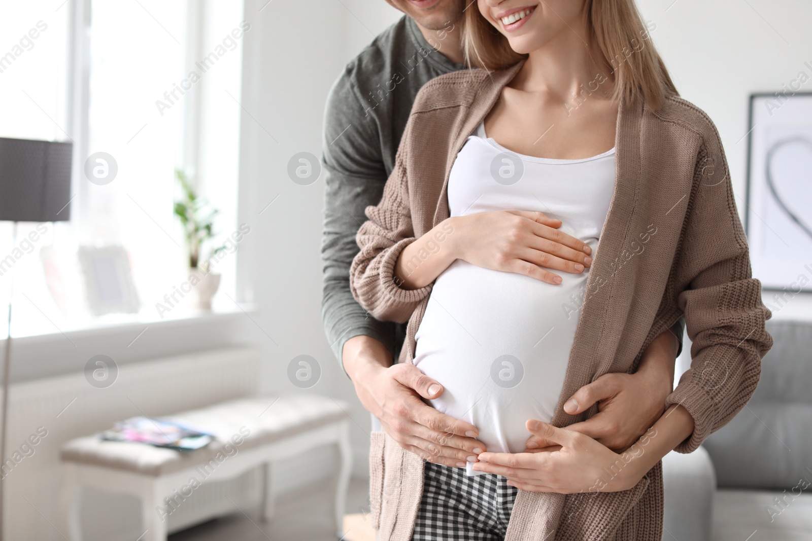 Photo of Young pregnant woman with her husband at home