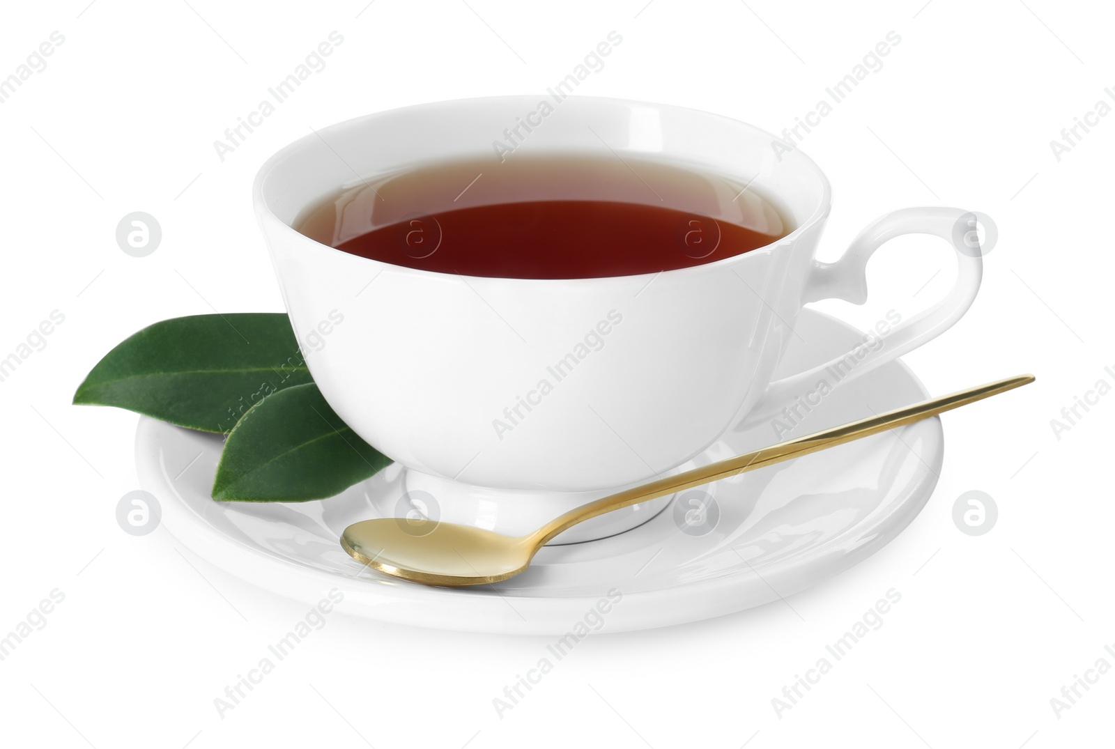 Photo of Aromatic tea in cup, golden spoon and green leaves isolated on white