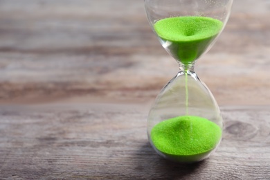 Hourglass with flowing sand on table. Time management