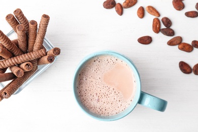 Mug with delicious hot cocoa drink and cookies on table, top view