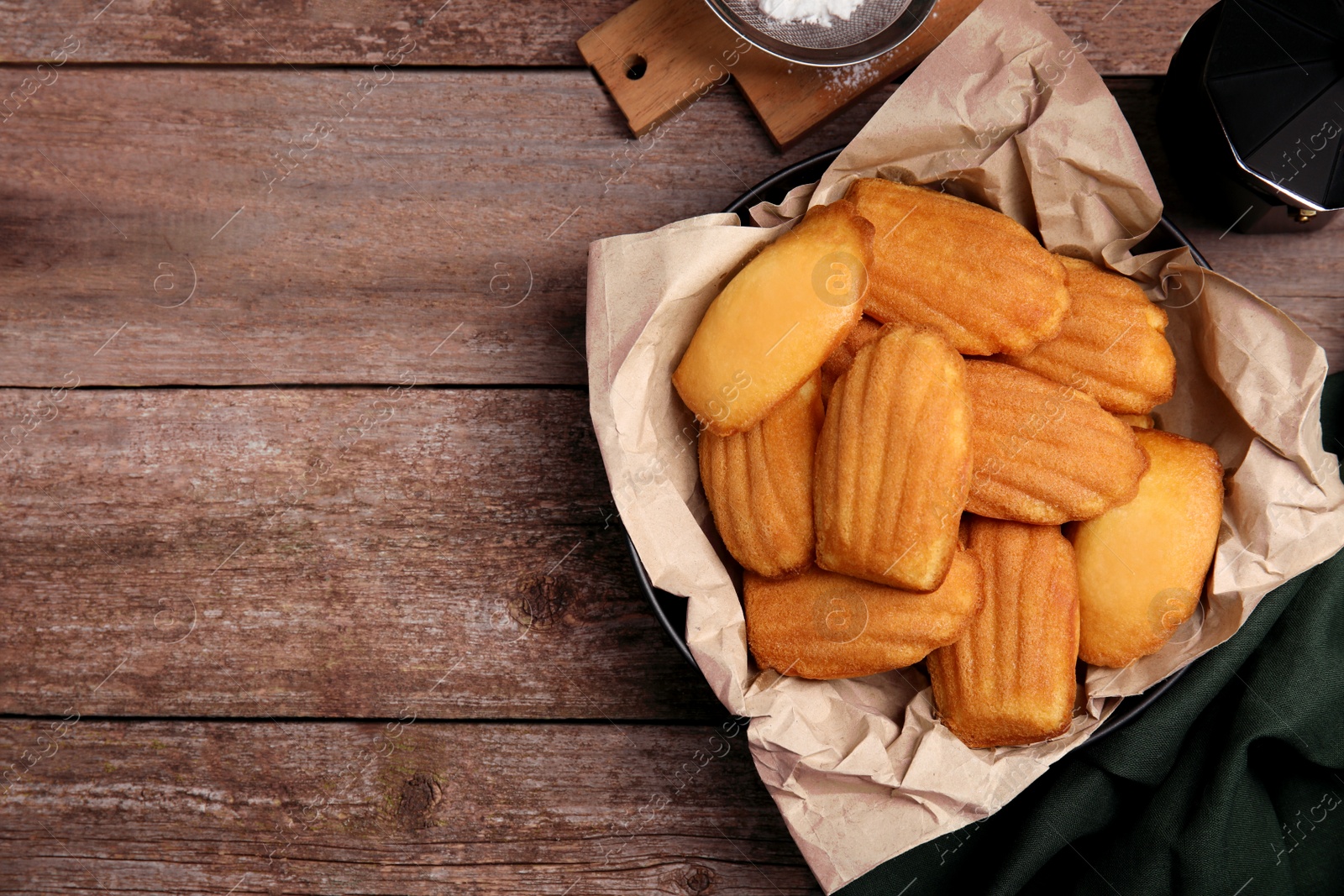 Photo of Delicious madeleine cakes on wooden table, flat lay. Space for text