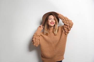 Photo of Beautiful young woman in warm sweater with hat on white background