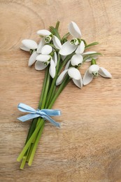 Beautiful snowdrops on wooden table, top view