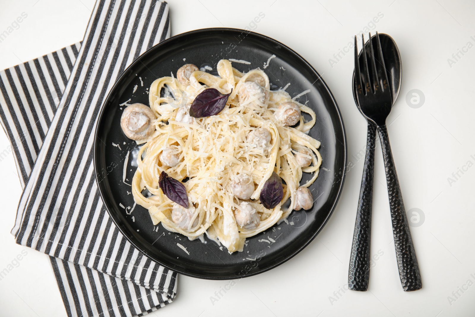 Photo of Delicious pasta with mushrooms served on white table, flat lay