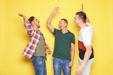 Group of friends celebrating victory against color background