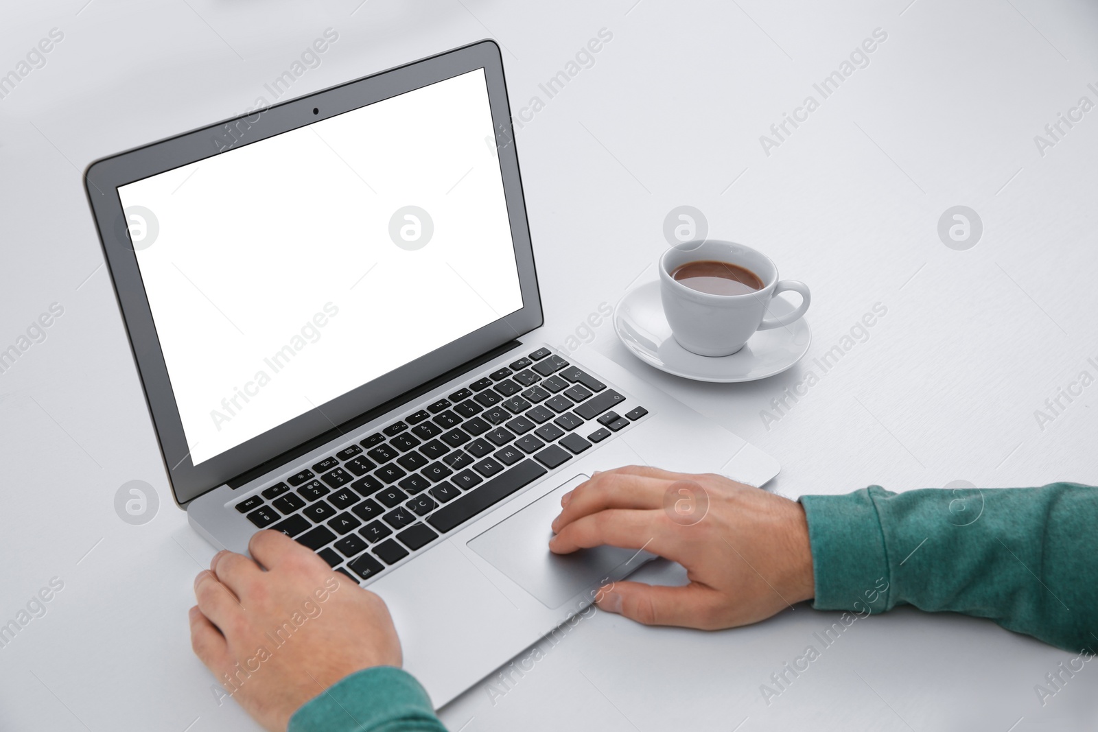 Photo of Young man working with modern laptop at table, closeup. Mockup for design