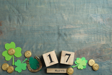 Photo of Flat lay composition with clover leaves and block calendar on light blue wooden background, space for text. St. Patrick's day