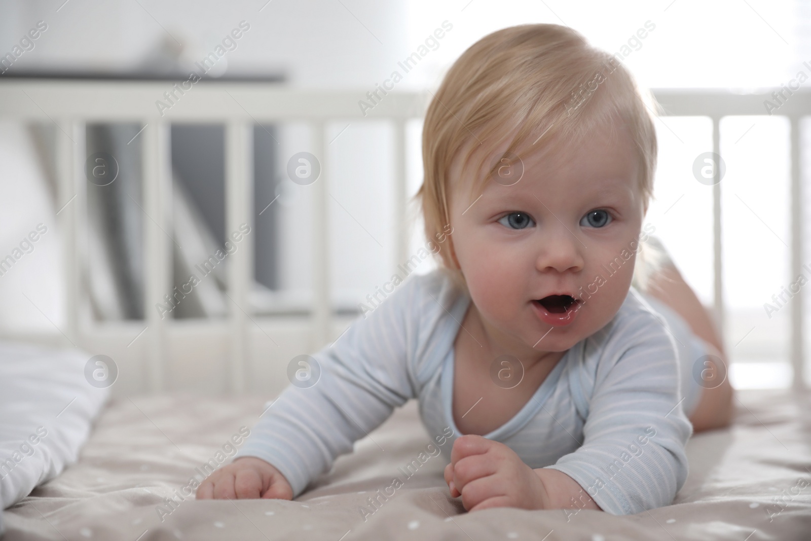 Photo of Adorable little baby lying in comfortable crib