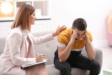 Photo of Psychotherapist working with young man in office