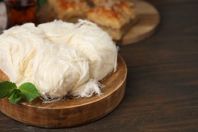 Photo of Eastern sweets. Tasty Iranian pashmak on wooden table, closeup. Space for text