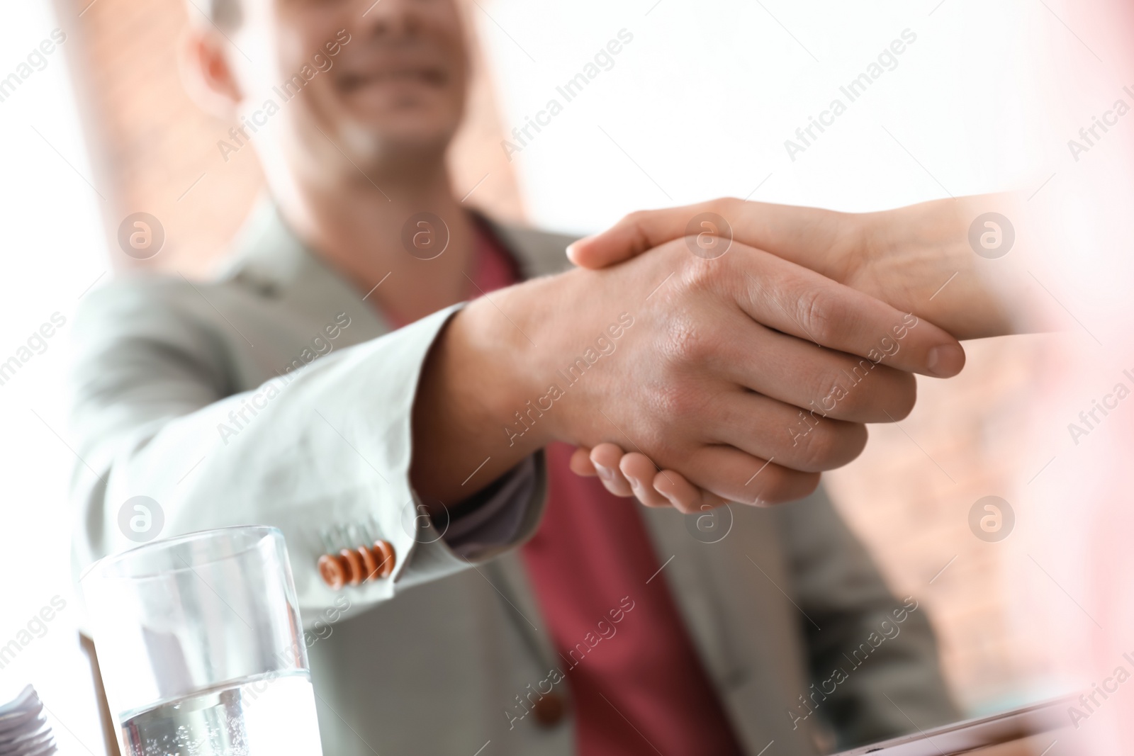 Photo of Business partners shaking hands after meeting, closeup