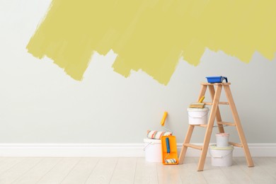 Image of Decorator's kit of tools and paints near wall indoors