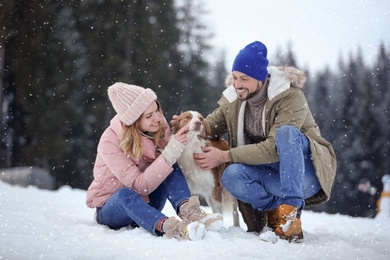 Cute couple with dog near forest. Winter vacation