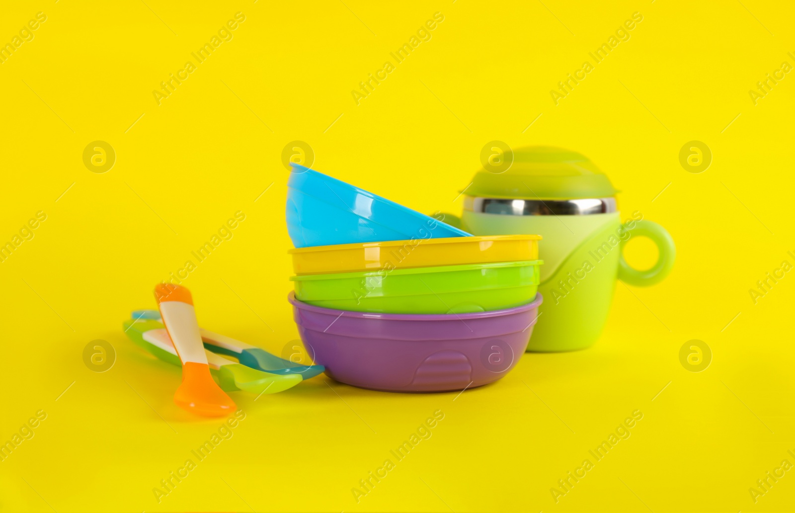 Photo of Set of plastic dishware on yellow background. Serving baby food