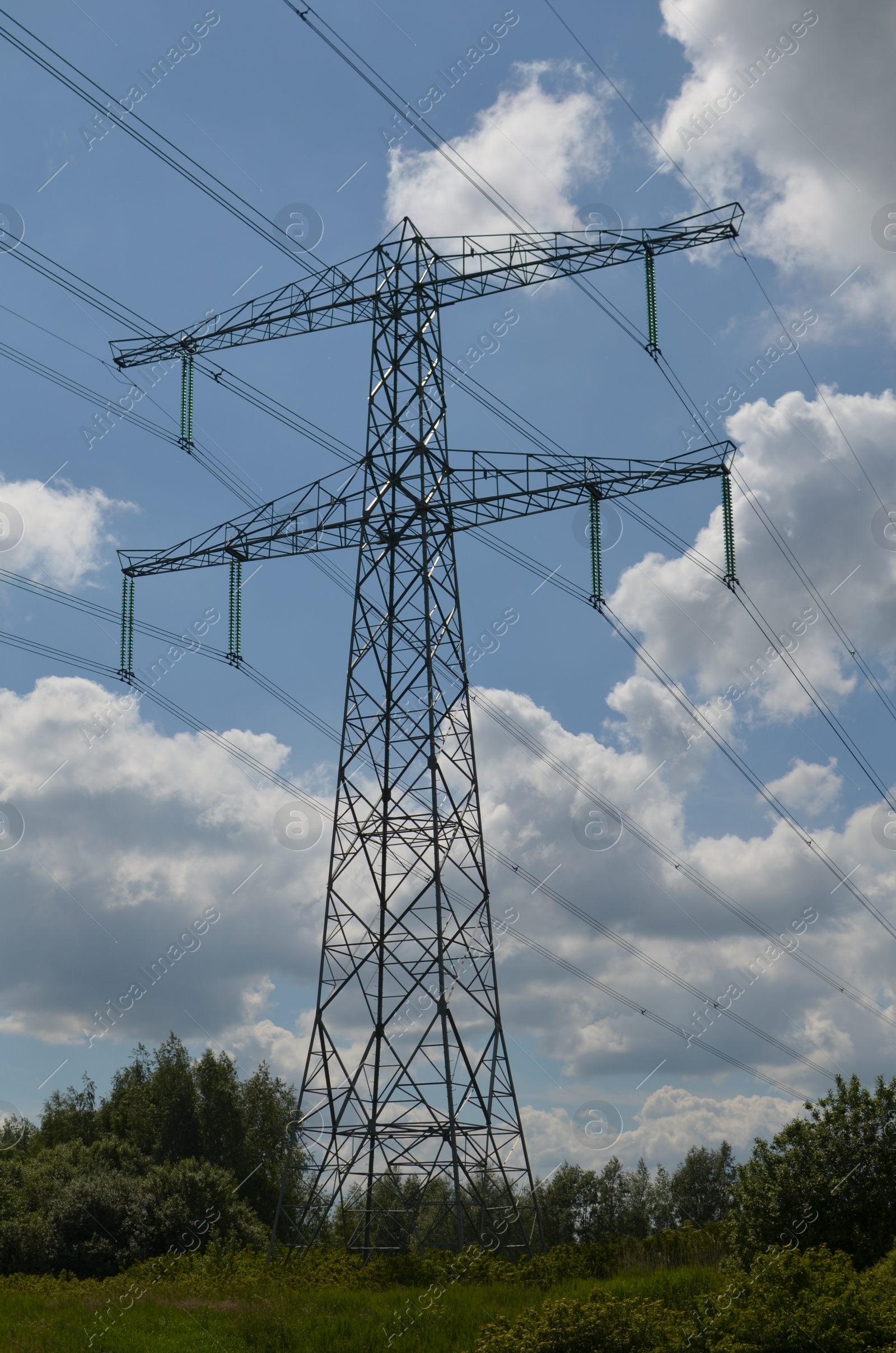 Photo of Modern high voltage tower in field on sunny day