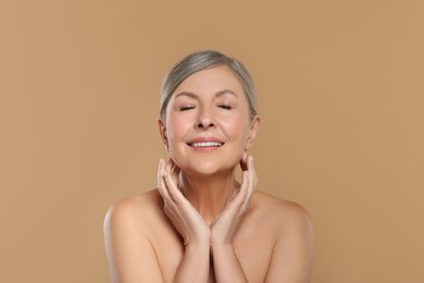 Photo of Beautiful mature woman with healthy skin on beige background