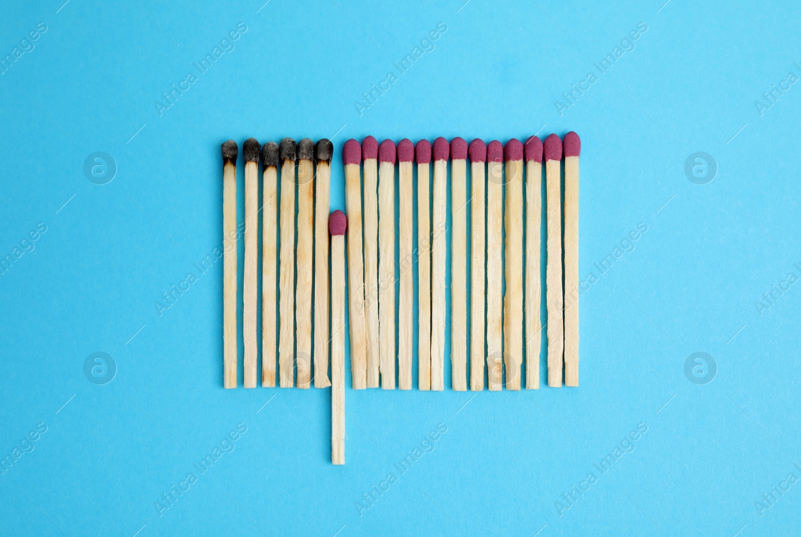 Photo of Flat lay composition with burnt and whole matches on light blue background