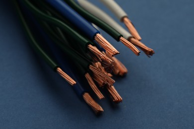 Photo of Electrical wires on blue background, closeup view