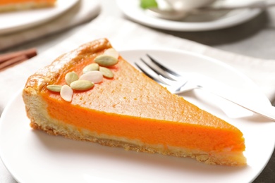 Photo of Plate with piece of fresh delicious homemade pumpkin pie on table, closeup