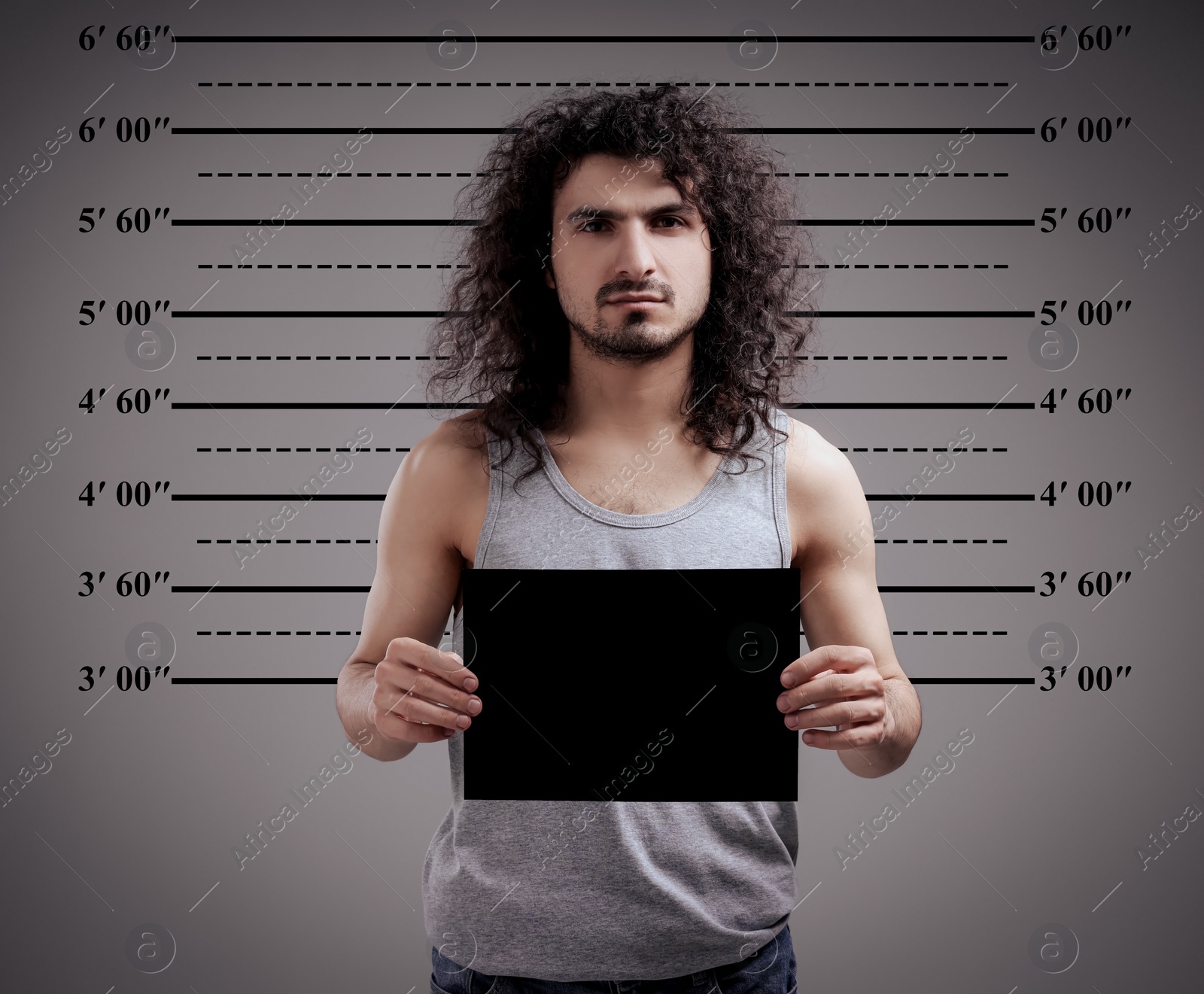 Image of Criminal mugshot. Arrested man with blank card against height chart