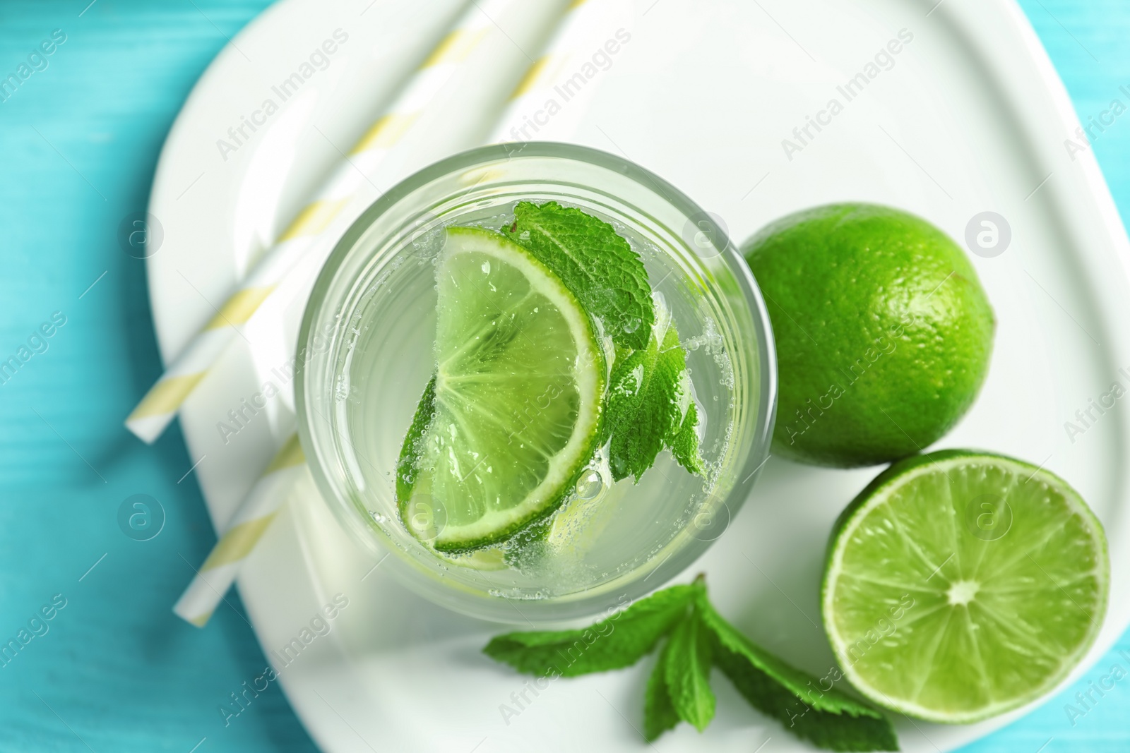 Photo of Natural lemonade with lime in glass on plate, closeup