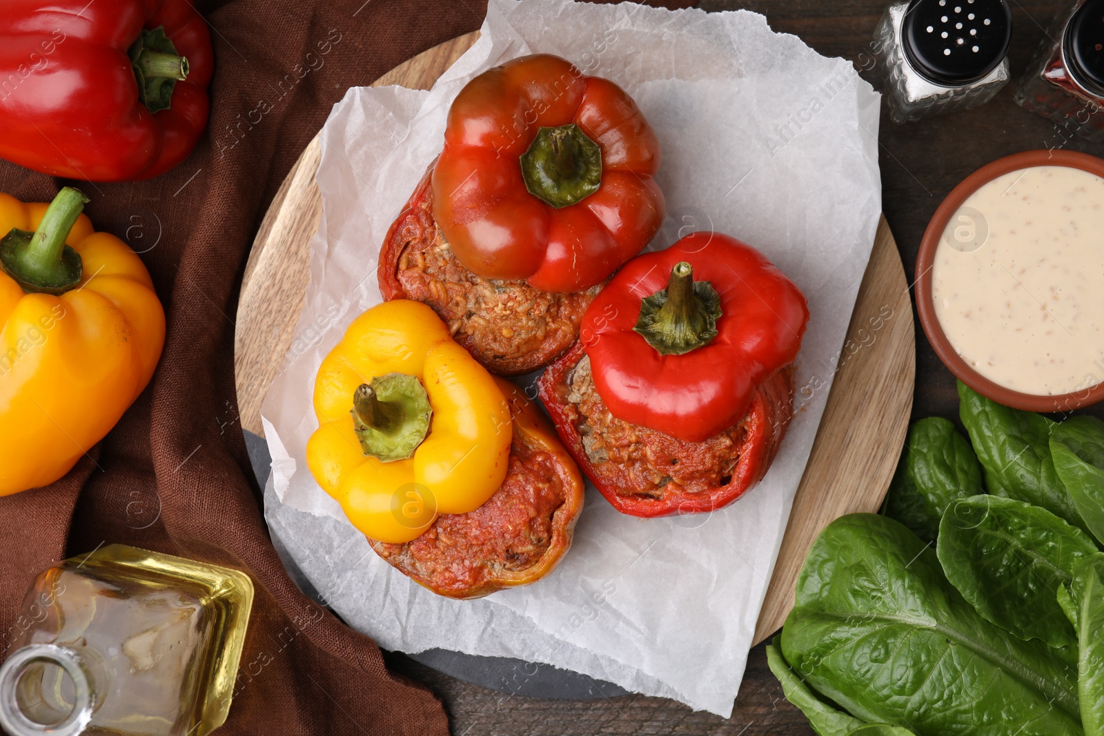 Photo of Delicious stuffed bell peppers served on wooden table, flat lay