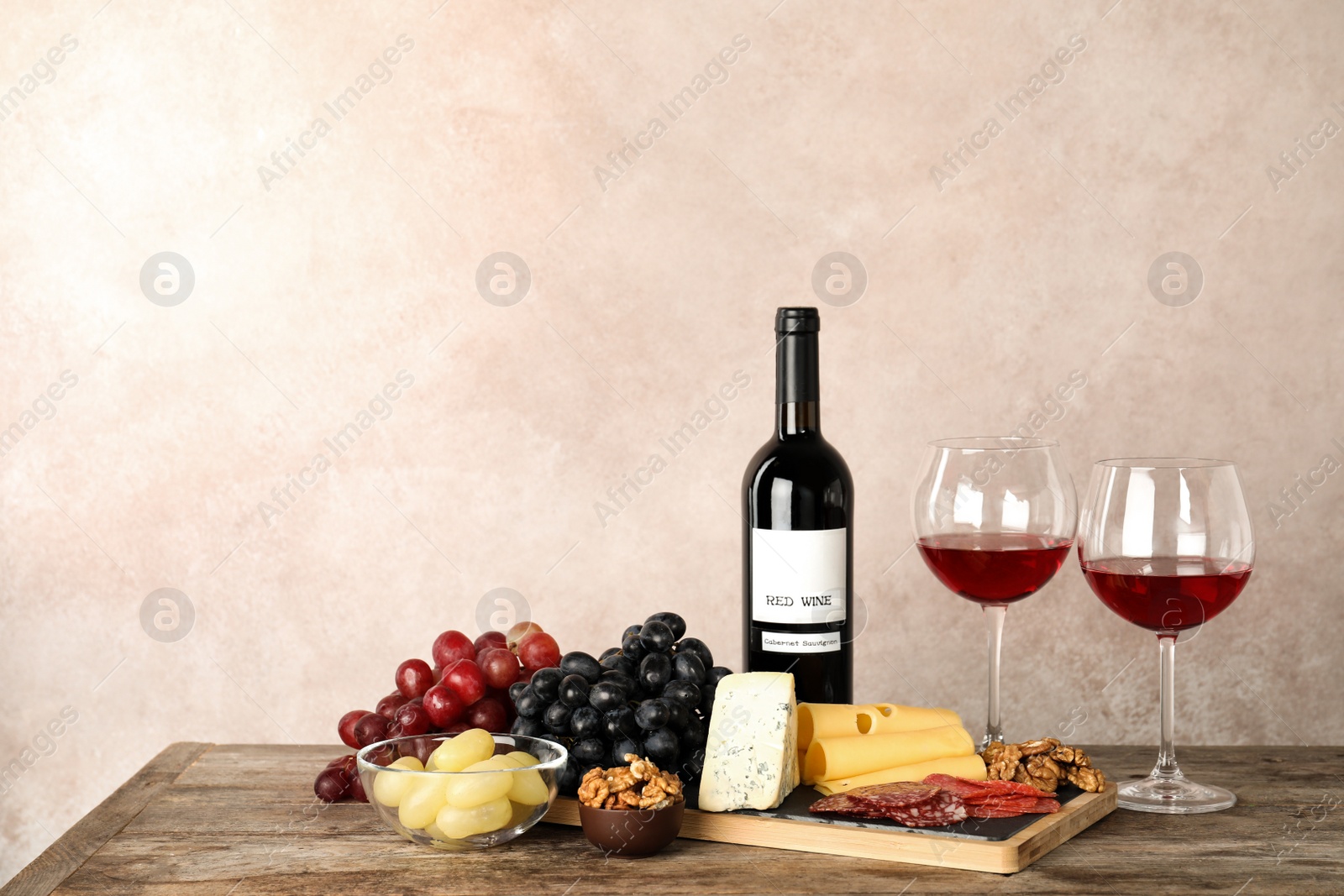 Photo of Composition with wine and snacks on table. Space for text