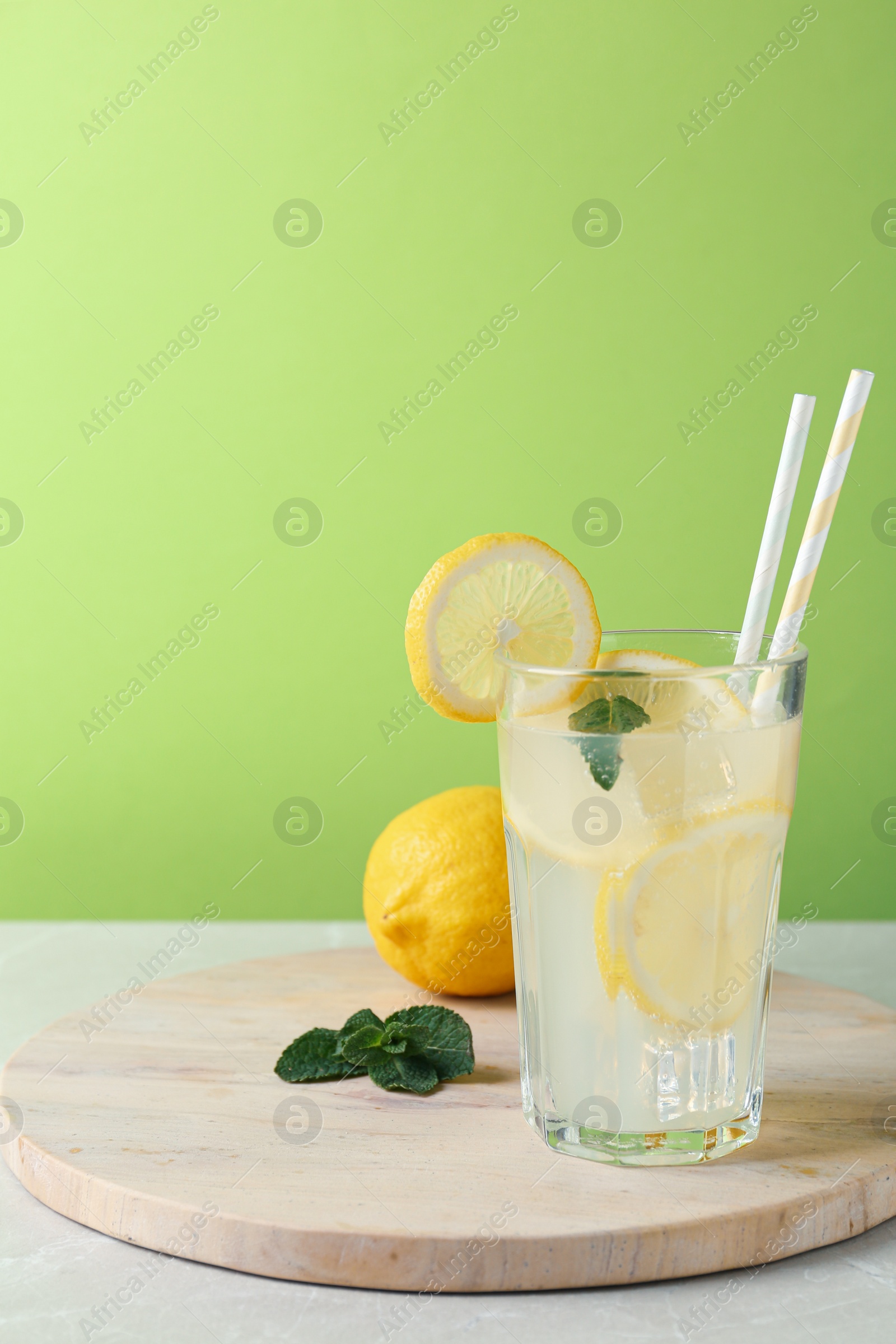 Photo of Delicious lemonade in glass on light table