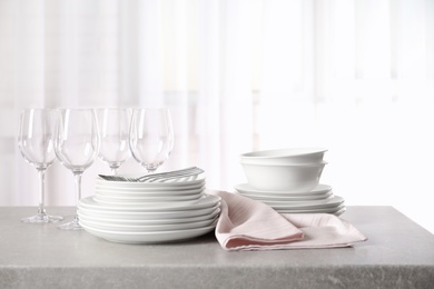 Set of clean dishes on table against blurred background