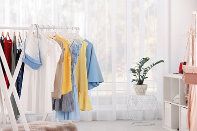 Racks with stylish clothes in light room