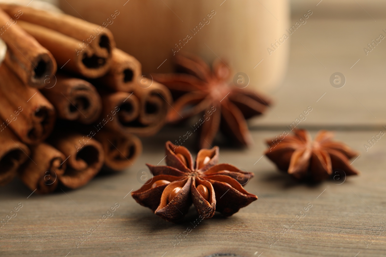 Photo of Cinnamon sticks and star anise on wooden table, closeup