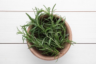 Photo of Bowl with fresh green rosemary on white wooden table, top view