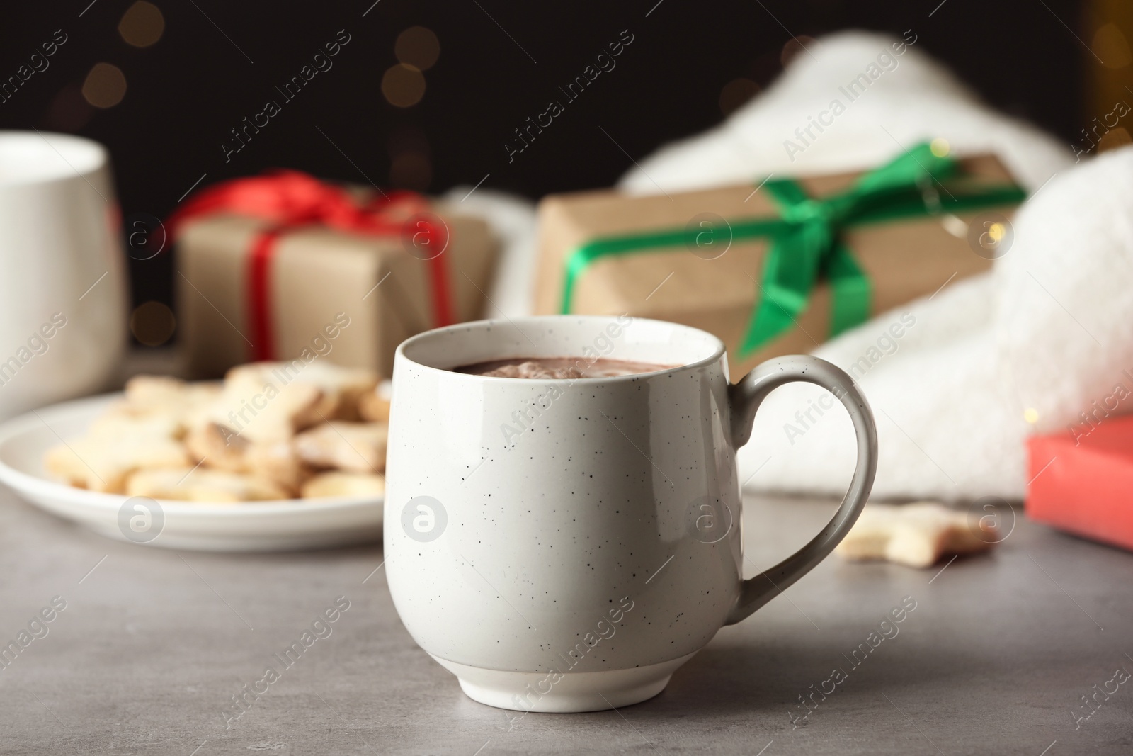 Photo of Delicious hot cocoa drink in white cup on grey table