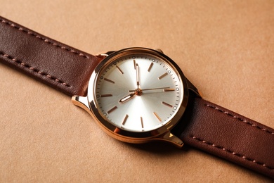 Luxury wrist watch on beige background, closeup