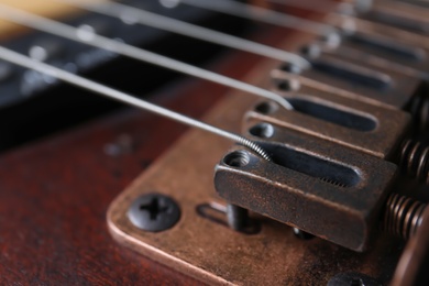 Photo of Closeup view of electric guitar, focus on bridge with strings