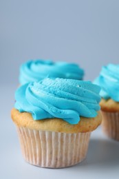 Delicious cupcakes with bright cream on light background, closeup