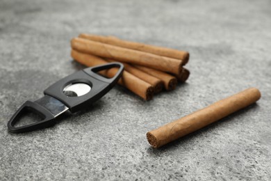 Photo of Cigars and guillotine cutter on grey table