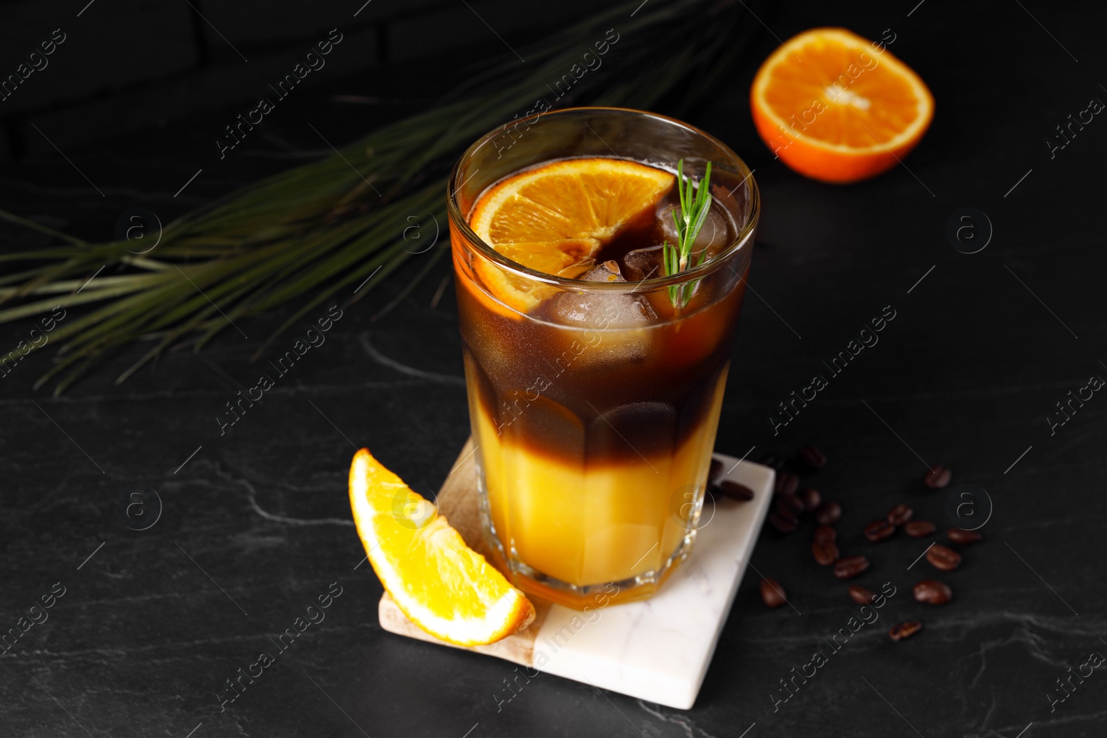 Photo of Tasty refreshing drink with coffee and orange juice on grey table