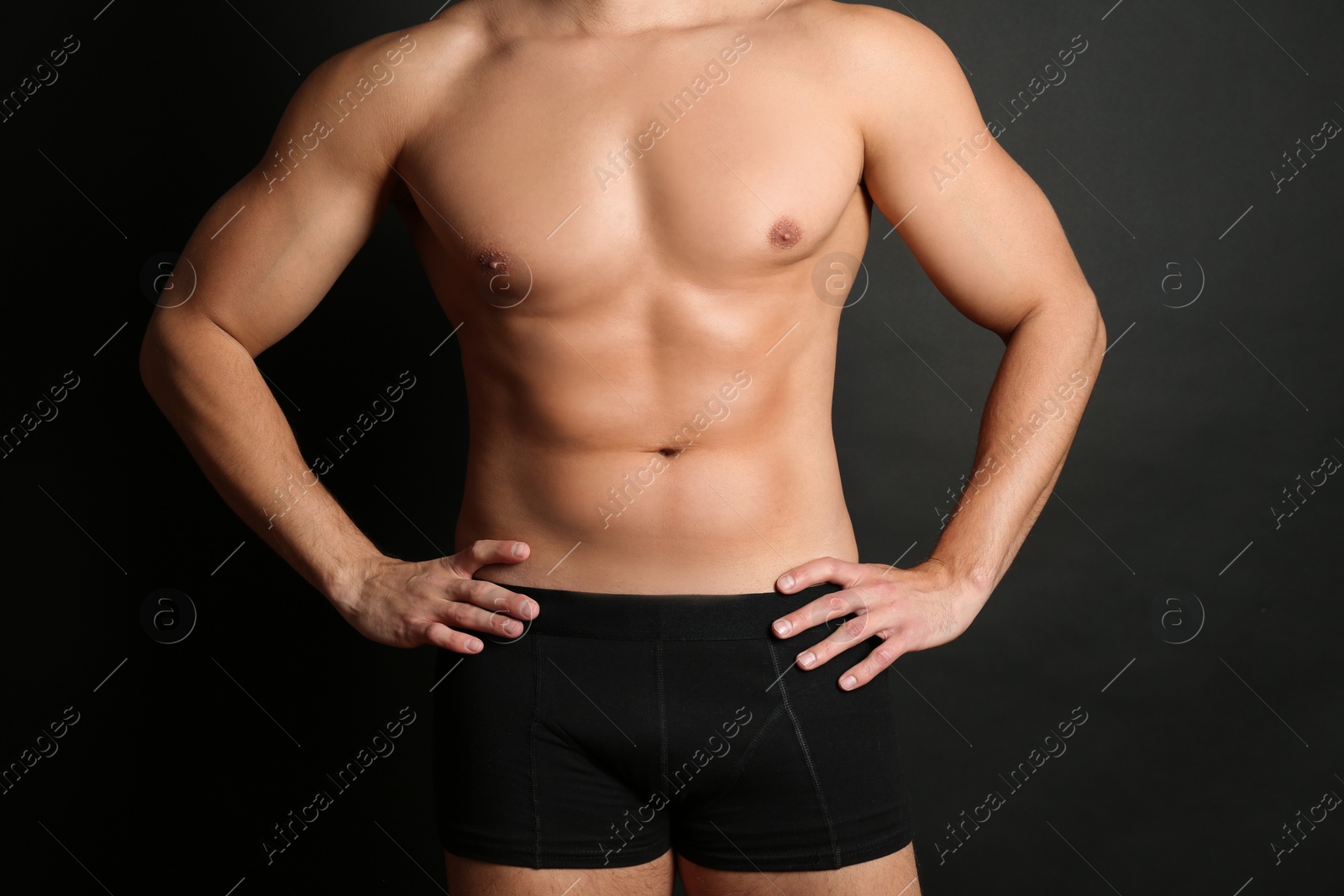 Photo of Man with sexy body on black background, closeup