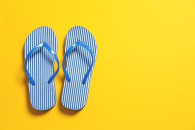 Photo of Bright flip flops on color background, top view with space for text. Beach accessories