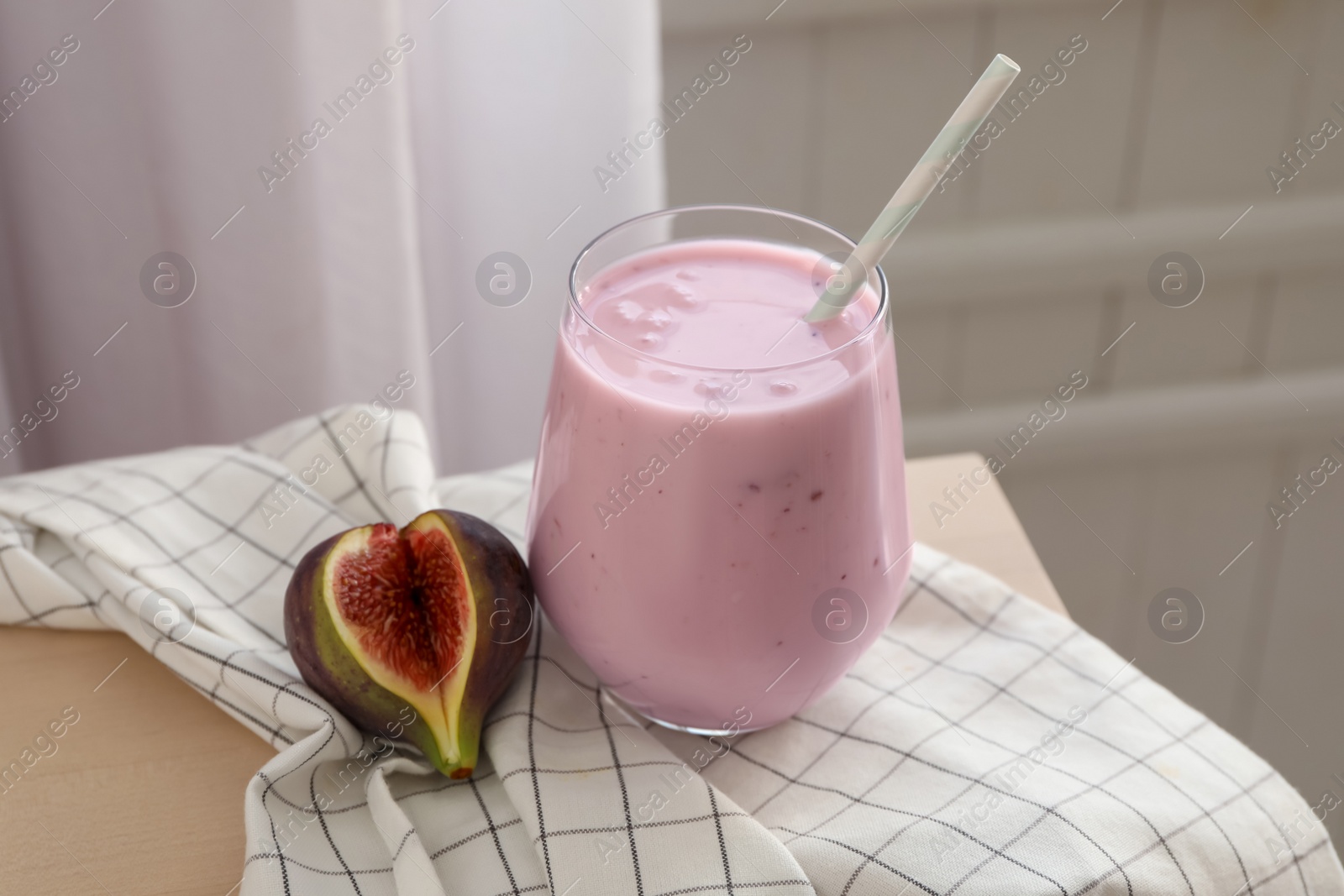 Photo of Delicious fig smoothie in glass on table indoors