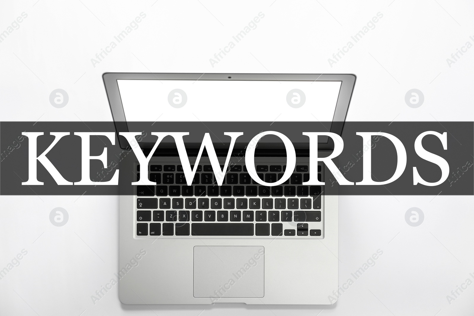 Image of Word Keywords and laptop on white background, top view. SEO direction